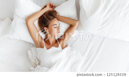 Close up of a Caucasian young woman sweet sleeping on white pillow. The young woman’s blissful sleep is highlighted by her gentle features on a white pillow. Close up of a Caucasian young woman sweet sleeping on white pillow. The young woman’s blissful sleep is highlighted by her gentle features on a white pillow. 125129339