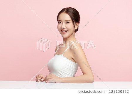 A beautiful young Asian woman with clean, fresh skin against a pink background. Skincare, facial treatment, cosmetology, beauty, and spa. An elegant portrait of an Asian woman. A beautiful young Asian woman with clean, fresh skin against a pink background. Skincare, facial treatment, cosmetology, beauty, and spa. An elegant portrait of an Asian woman. 125130322