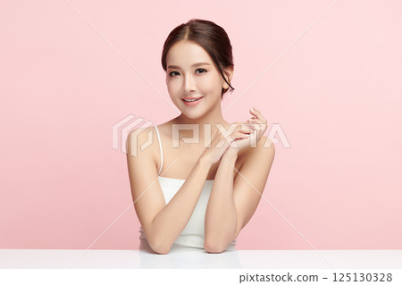A beautiful young Asian woman with clean, fresh skin against a pink background. Skincare, facial treatment, cosmetology, beauty, and spa. An elegant portrait of an Asian woman. A beautiful young Asian woman with clean, fresh skin against a pink background. Skincare, facial treatment, cosmetology, beauty, and spa. An elegant portrait of an Asian woman. 125130328