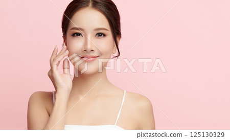 A beautiful young Asian woman with clean, fresh skin against a pink background. Skincare, facial treatment, cosmetology, beauty, and spa. An elegant portrait of an Asian woman. A beautiful young Asian woman with clean, fresh skin against a pink background. Skincare, facial treatment, cosmetology, beauty, and spa. An elegant portrait of an Asian woman. 125130329