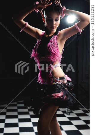 One elegant tango dancer, on a black background, and black and white checkerboard tiles, passionately stopped in motion during the dance One elegant tango dancer, on a black background, and black and white checkerboard tiles, passionately stopped in motion during the dance 125131255