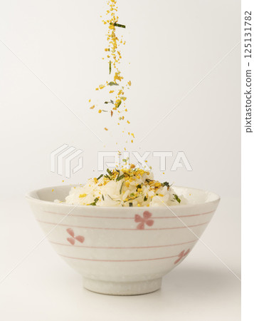 將海苔蛋拌飯撒在熱飯上 將海苔蛋拌飯撒在熱飯上 125131782