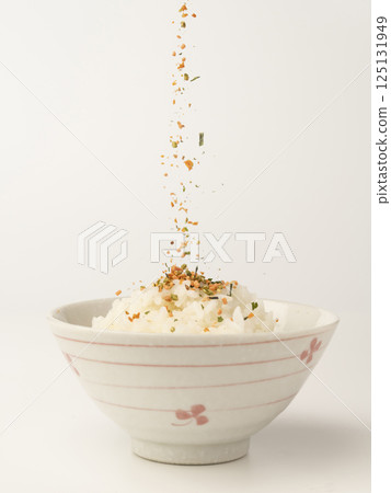 將鮭魚和海藻拌飯放在熱飯上 將鮭魚和海藻拌飯放在熱飯上 125131949