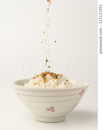 將鮭魚和海藻拌飯放在熱飯上 125131951