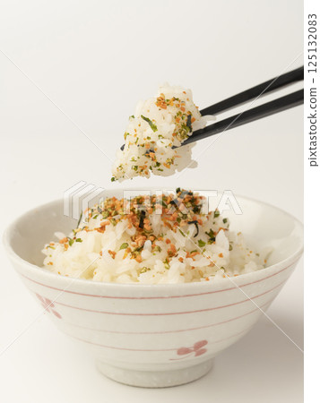 Pick up warm rice topped with salmon and seaweed sprinkles with chopsticks Pick up warm rice topped with salmon and seaweed sprinkles with chopsticks 125132083