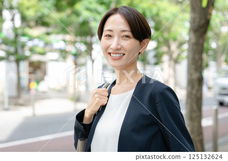 A woman in a suit walking through the city 125132624