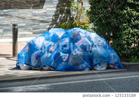 A pile of garbage wrapped in a blue net 125133189