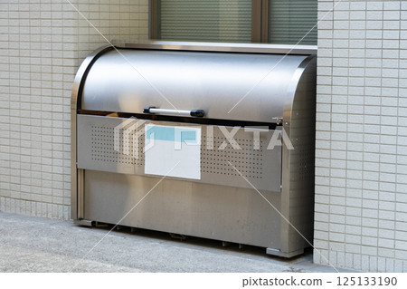 公寓大樓外安裝的大型金屬垃圾收集箱 125133190