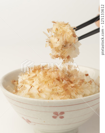 Pick up warm rice topped with bonito flakes with chopsticks 125133612