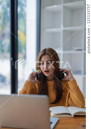 young woman happy, viewing her excellent success score in her e-learning program displayed on her laptop at her desk at home young woman happy, viewing her excellent success score in her e-learning program displayed on her laptop at her desk at home 125133757