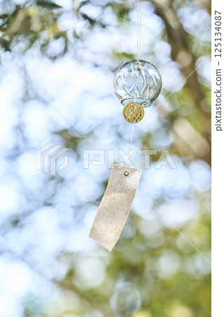Wind chimes swaying in the wind under the summer sunlight 125134087