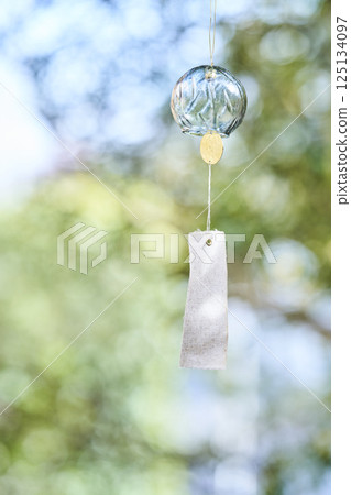 Wind chimes swaying in the wind under the summer sunlight 125134097