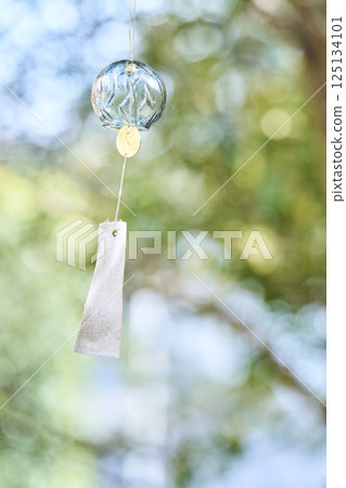 Wind chimes swaying in the wind under the summer sunlight Wind chimes swaying in the wind under the summer sunlight 125134101