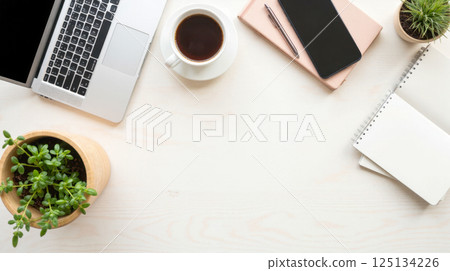 Minimal creative workspace with laptop coffee notebook smartphone and green plants on clean desk background for productivity and freelance work Minimal creative workspace with laptop coffee notebook smartphone and green plants on clean desk background for productivity and freelance work 125134226
