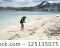 Boy going into the sea on a cold day 125135075