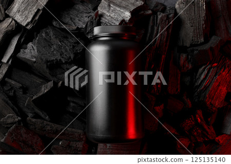 Black plastic jar on dark background, top view Black plastic jar on dark background, top view 125135140