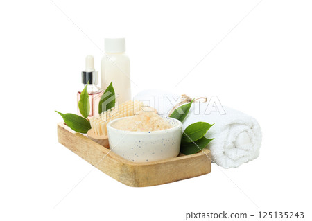 Sea salt in bowl, leaves, brush, towel and bottles on white background, close up 125135243
