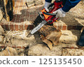 Cutting timber with a chainsaw 125135450