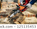 Cutting timber with a chainsaw 125135453