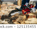 Cutting timber with a chainsaw 125135455