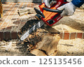 Cutting timber with a chainsaw 125135456