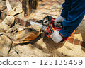 Cutting timber with a chainsaw 125135459
