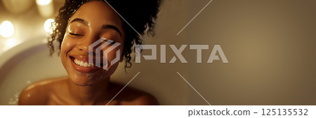 A beautiful woman with radiant skin gently applying facial cream, exuding a sense of self-care and beauty. skincare, beauty products, and wellness promotions 125135532