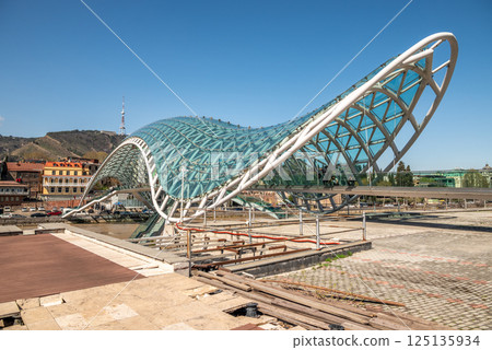 Peace bridge, steel and glass construction pedestrian bridge over Kura Mtkvari river in central Tbilisi, Georgia 125135934