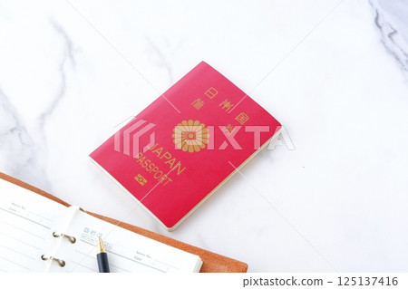 Image of someone preparing a Japanese passport (10-year regular passport, red) and planning a trip abroad Image of someone preparing a Japanese passport (10-year regular passport, red) and planning a trip abroad 125137416