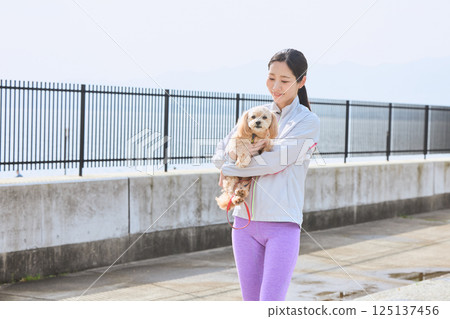 A woman enjoying jogging with her dog A woman enjoying jogging with her dog 125137456
