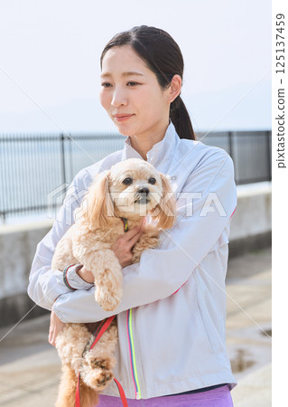 A woman enjoying jogging with her dog A woman enjoying jogging with her dog 125137459
