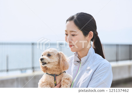 一位女士正和她的狗一起享受慢跑 125137462