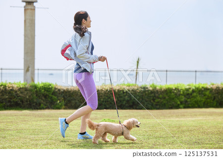 一位女士正和她的狗一起享受慢跑 125137531