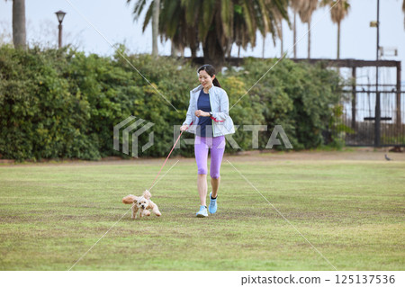 A woman enjoying jogging with her dog A woman enjoying jogging with her dog 125137536