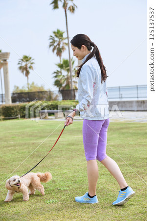 A woman enjoying jogging with her dog 125137537