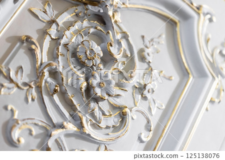 Ornate baroque-style floral wall decoration accentuated with gold paint Ornate baroque-style floral wall decoration accentuated with gold paint 125138076