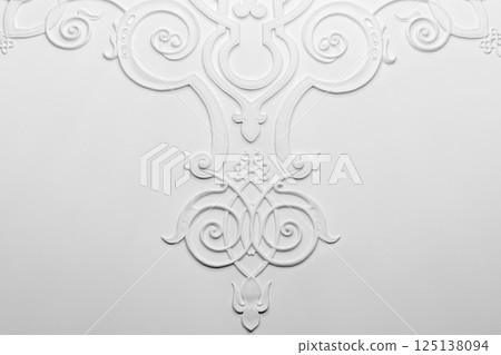 Symmetric white plaster relief showcasing elegant floral design 125138094