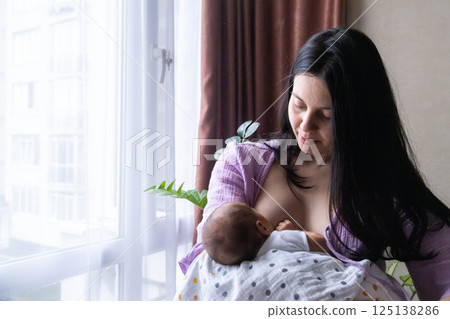 Mother Breastfeeding Baby by Window Mother Breastfeeding Baby by Window 125138286