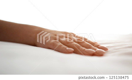 Woman touching soft white sheets in hotel room 125138475