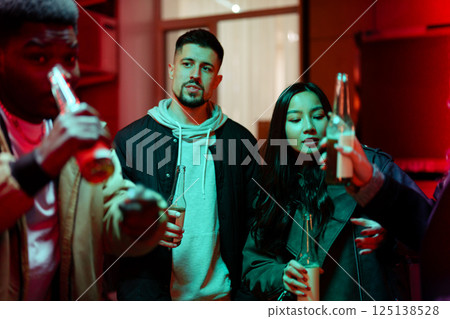 Friends enjoying drinks together in an urban setting during a vibrant evening gathering 125138528