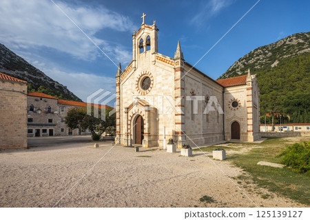 Ston, historic town in Peljesac peninsula in Croatia, Europe. Picturesque church nestled in serene landscape under clear sky, architectural elegance meets tranquil nature backdrop. Timeless beauty! Ston, historic town in Peljesac peninsula in Croatia, Europe. Picturesque church nestled in serene landscape under clear sky, architectural elegance meets tranquil nature backdrop. Timeless beauty! 125139127