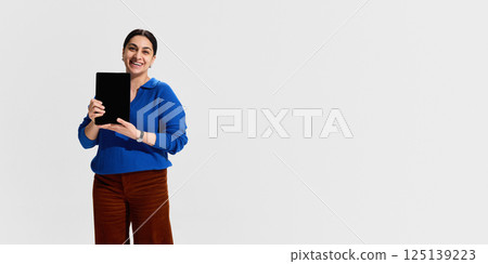 Smiling woman, university instructor holding digital tablet, symbolizing openness, enthusiasm and tech-friendly attitude during online education 125139223
