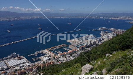 Gibraltar harbor with ships sailing on a sunny day with blue sky 125139576