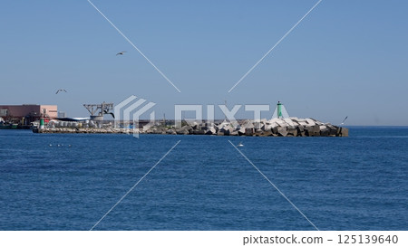 Estepona beach reflecting on calm mediterranean sea under blue sky in Marbella Spain Estepona beach reflecting on calm mediterranean sea under blue sky in Marbella Spain 125139640
