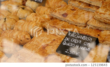 Spanish puff pastry with cadiz crackling cheese and egg filling sitting in bakery display case 125139643