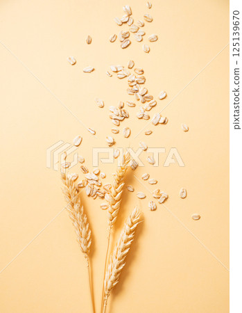 Oat flakes with wheat scattered on a yellow background. Healthy eating and wholesome diet breakfast Oat flakes with wheat scattered on a yellow background. Healthy eating and wholesome diet breakfast 125139670