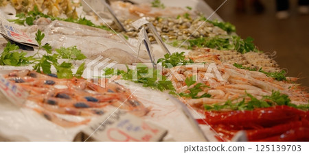 Fresh seafood displayed on ice at a market, featuring shrimp, squid, and other delicacies Fresh seafood displayed on ice at a market, featuring shrimp, squid, and other delicacies 125139703