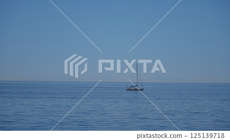 Sailboat sailing in a calm sea with clear blue sky 125139718