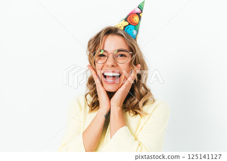 A woman wearing a party hat and glasses is smiling and making a silly face A woman wearing a party hat and glasses is smiling and making a silly face 125141127
