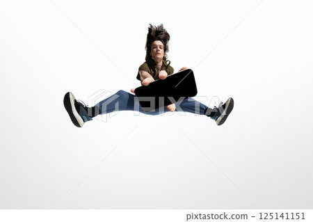 Energetic man in mid-air jump holding smartphone mockup straight to lens in extreme motion pose against white background 125141151